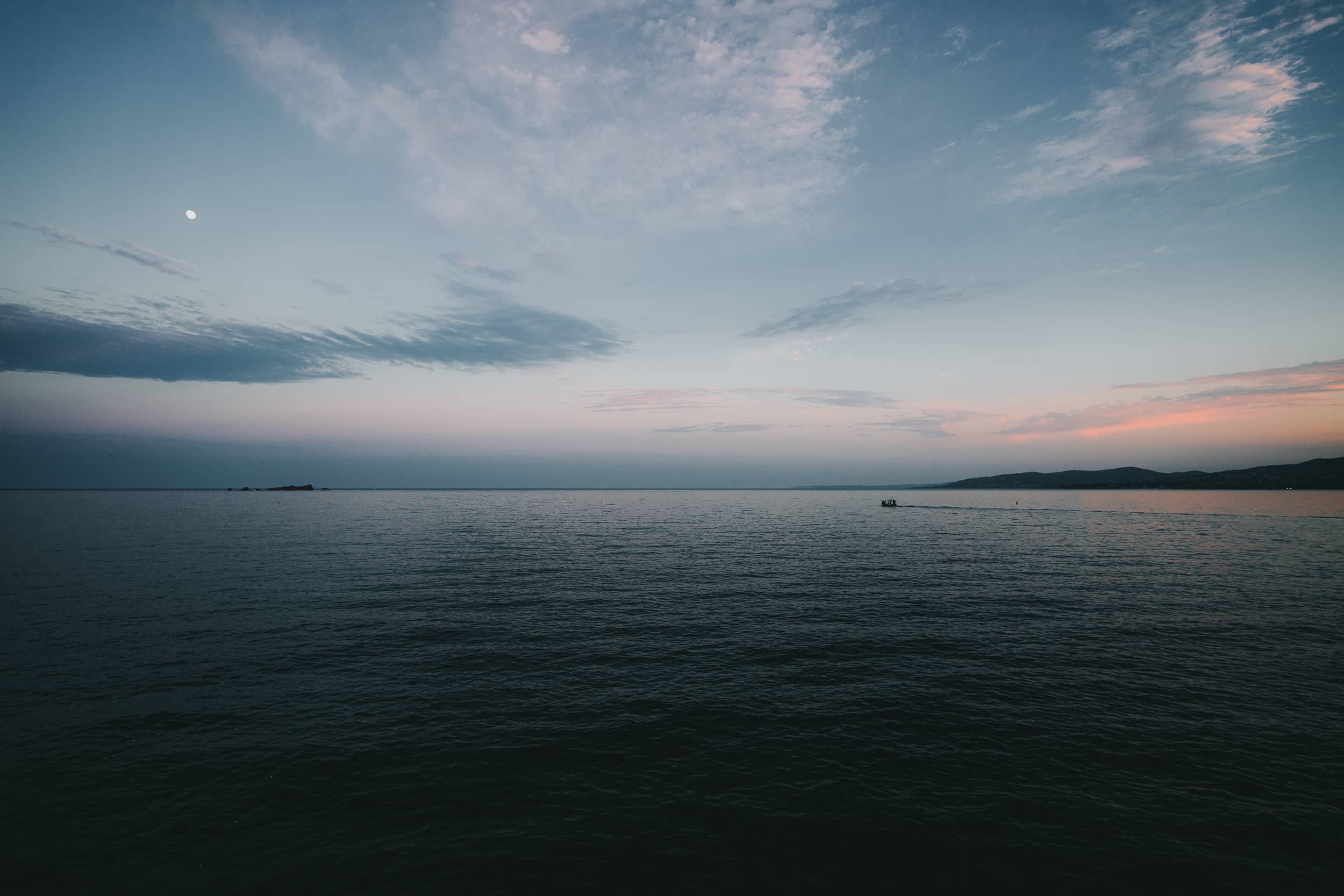 Mer calme au crépuscule, horizon rose et bleu